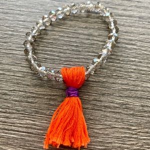 Boho bracelet with tangerine and violet tassel.  One size